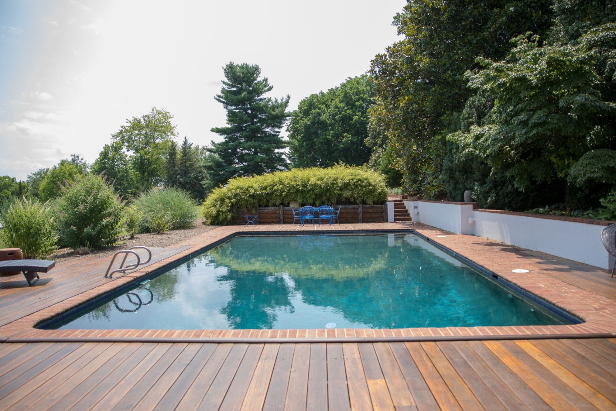 Rectangular pool in wooded area.