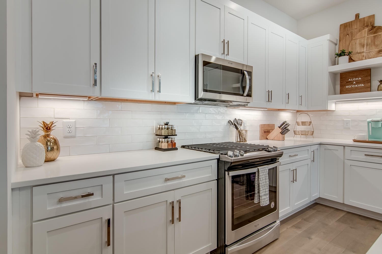 Modern white kitchen with stainless appliances.