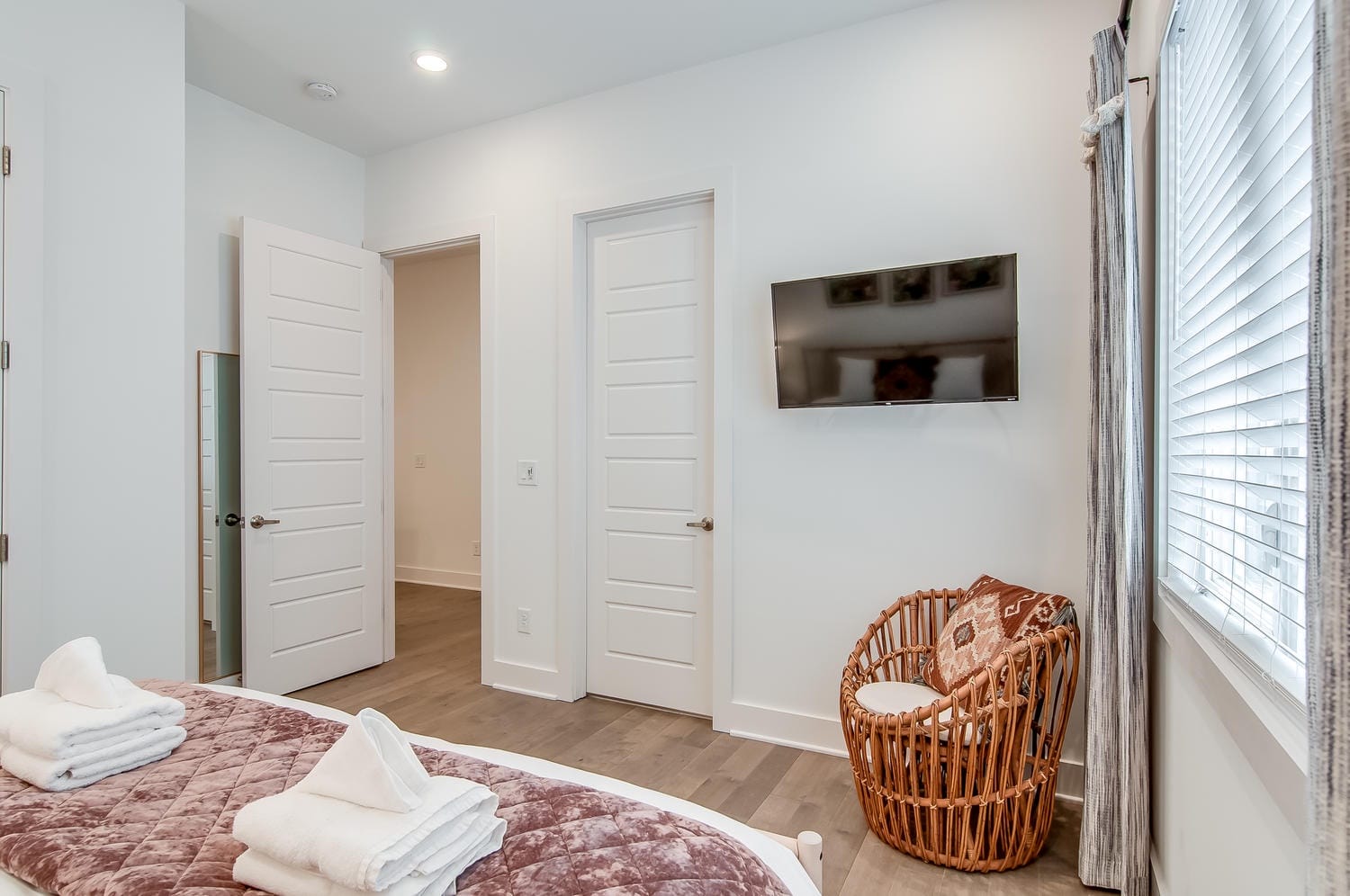 Modern bedroom with basket chair, TV.