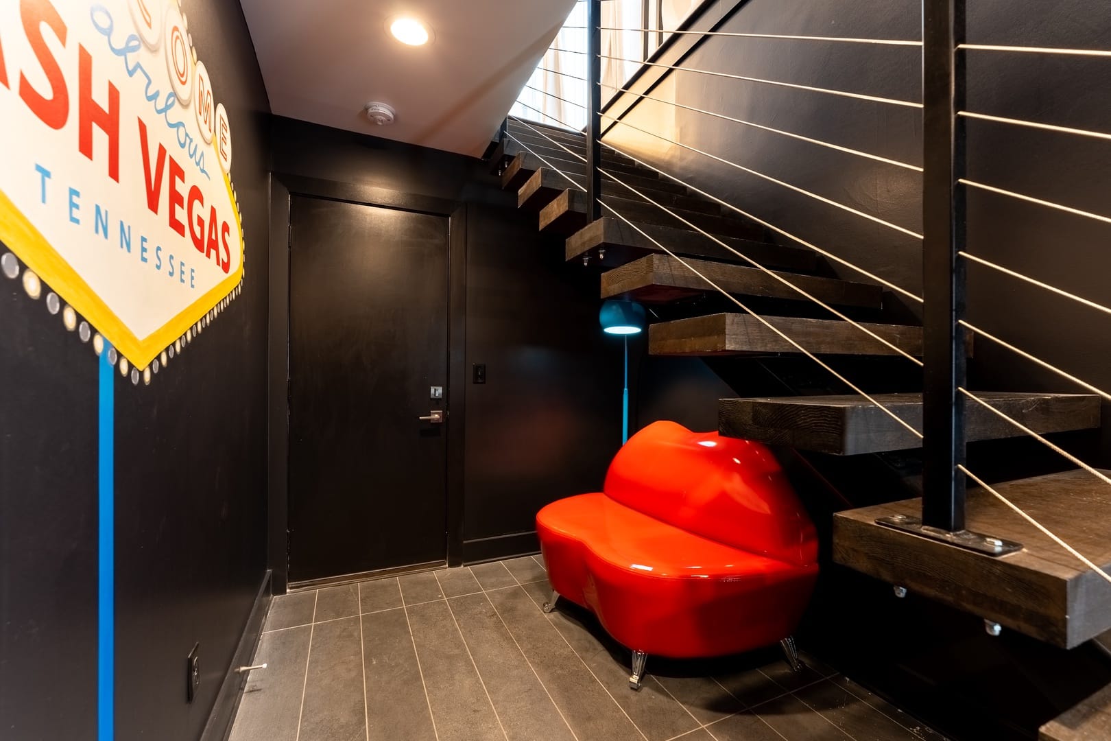 Modern hallway with stairs and sign.