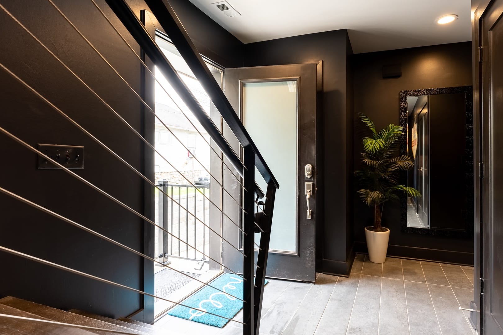 Modern entryway with staircase railing.