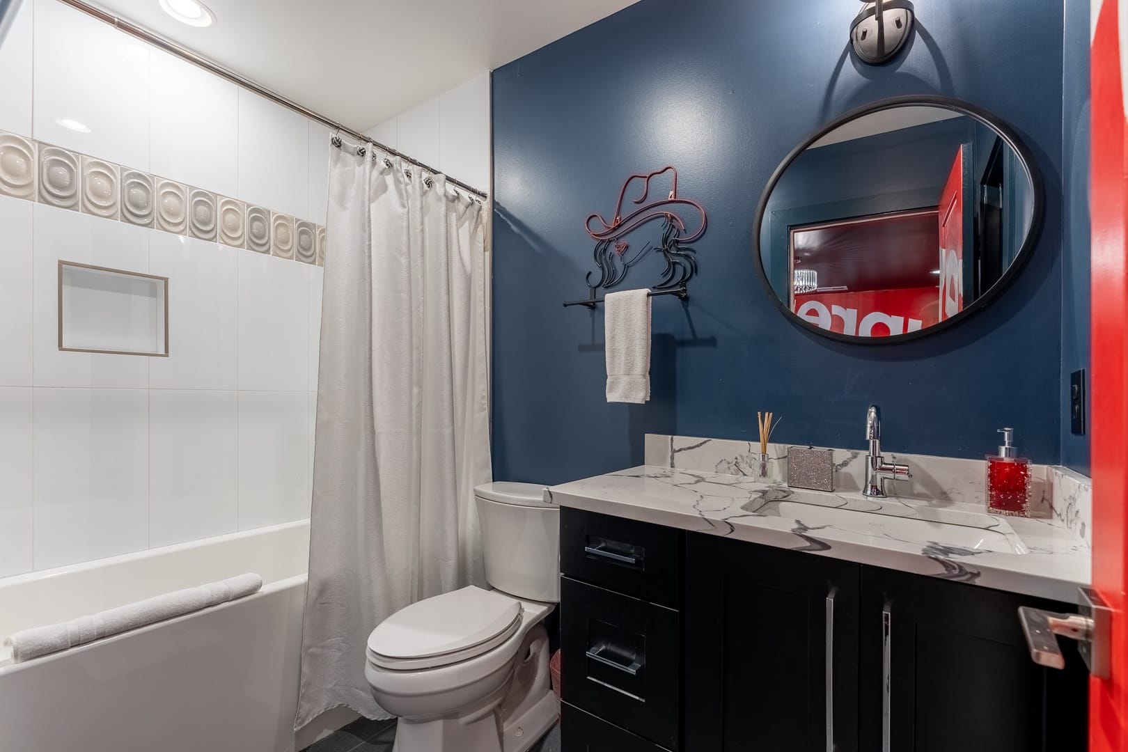 Modern bathroom with circular mirror.