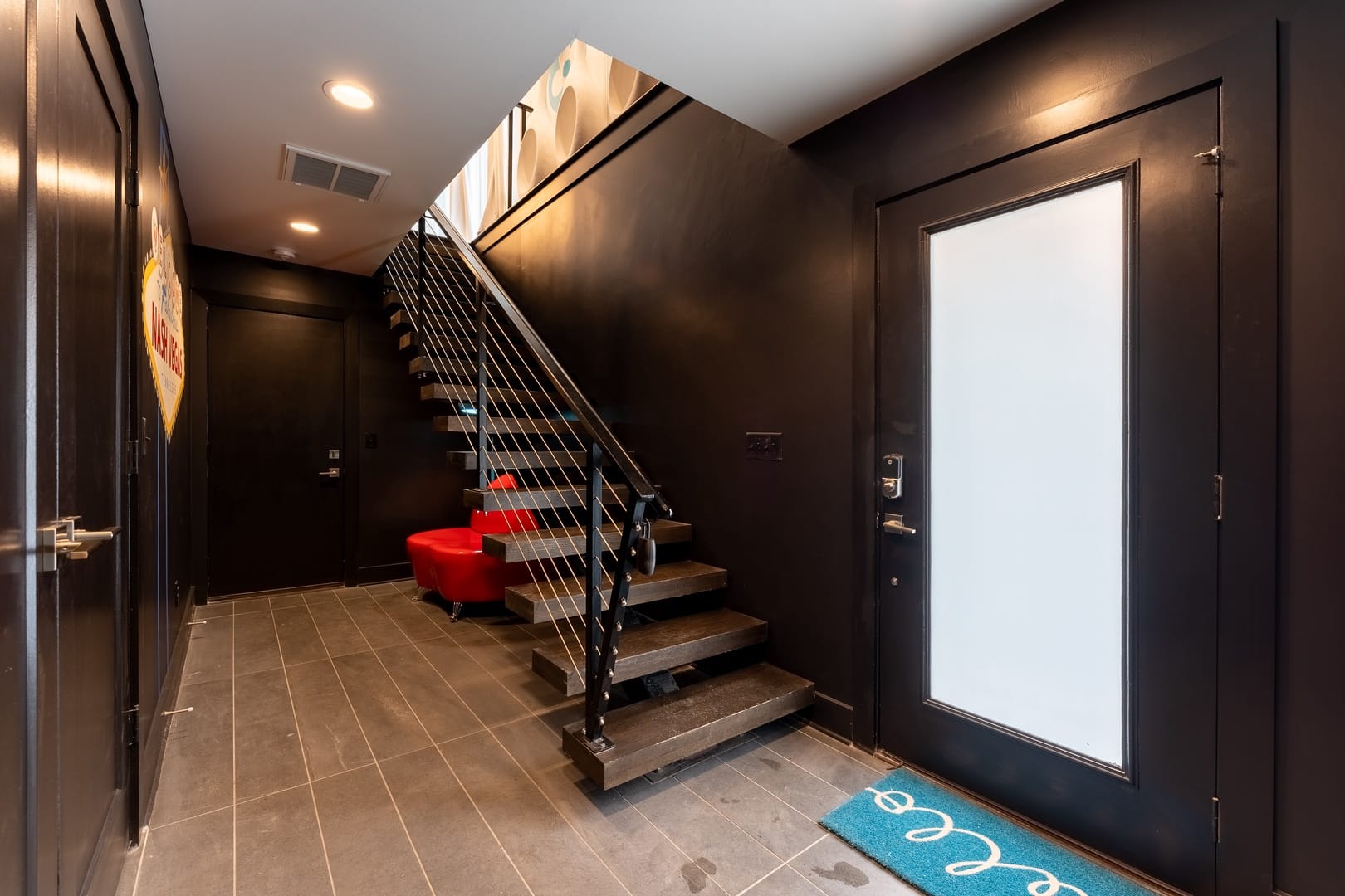 Modern entryway with black staircase.