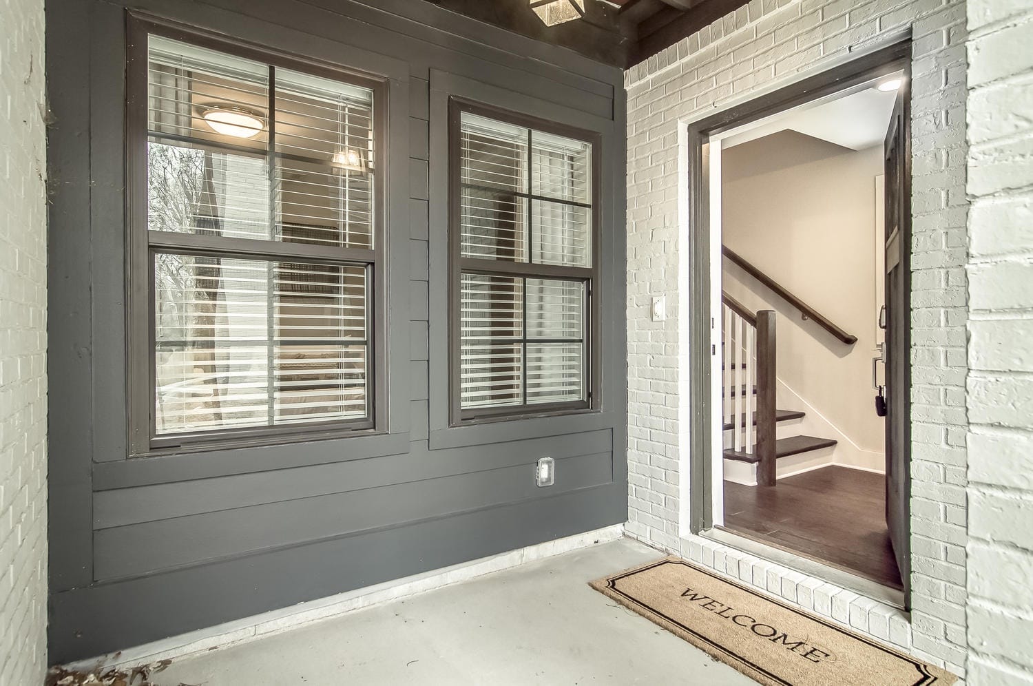 Exterior entryway with welcome mat.