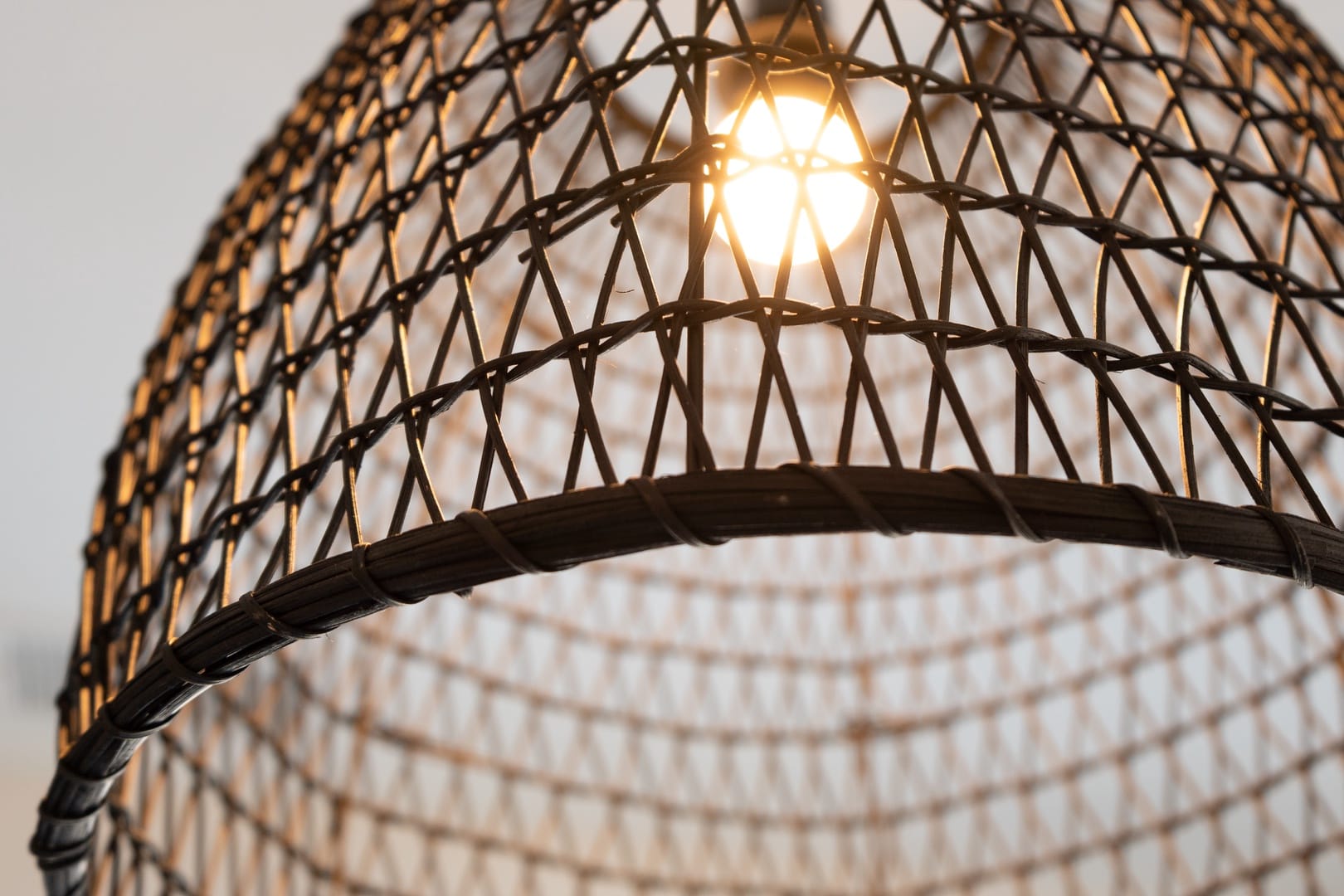 Wicker light fixture, bulb glowing.