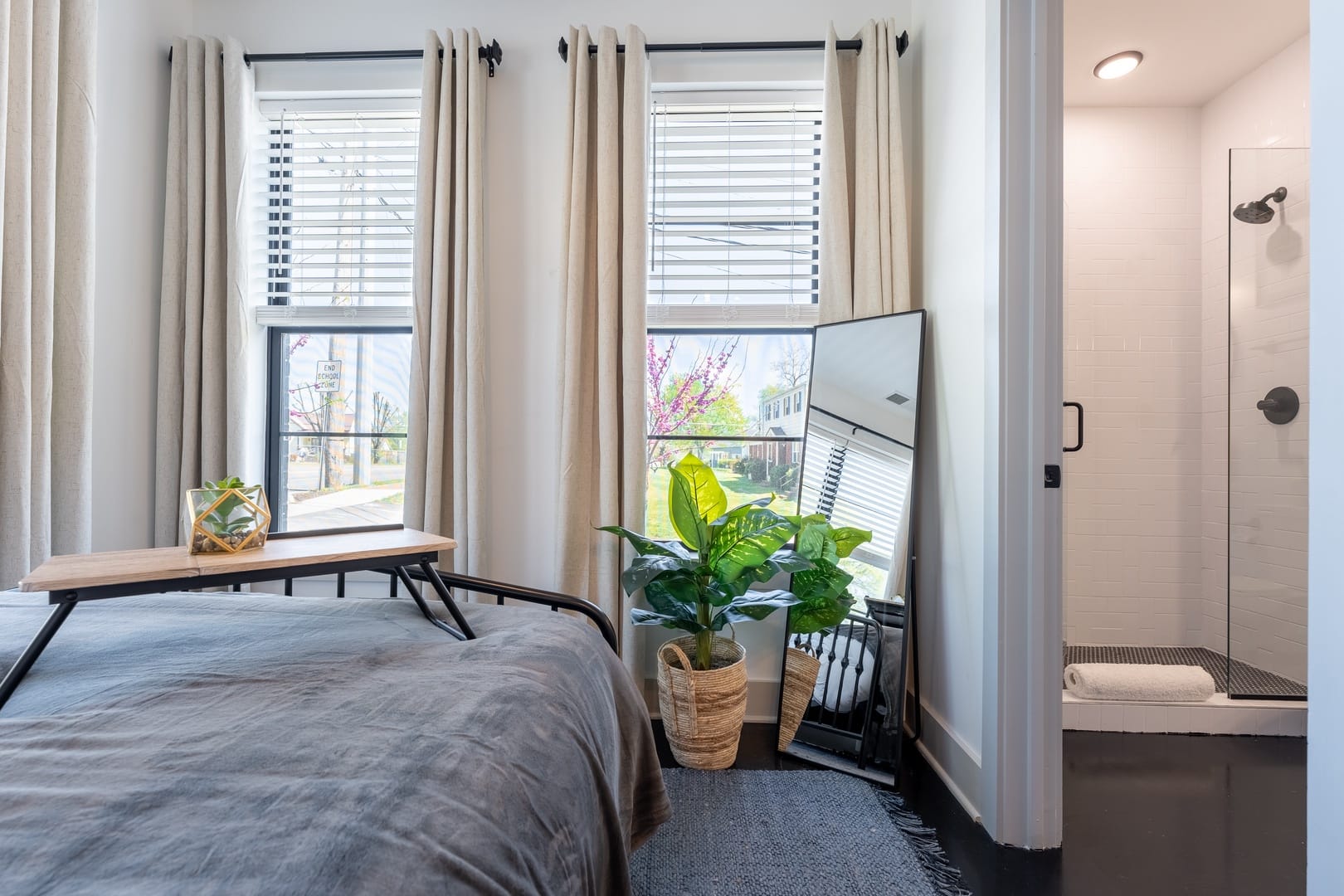 Bedroom with windows, plants, shower.