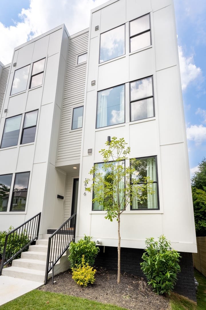 Modern white three-story townhouse exterior.