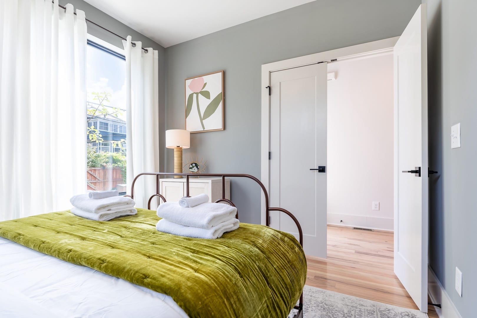 Bright bedroom with green bedspread.