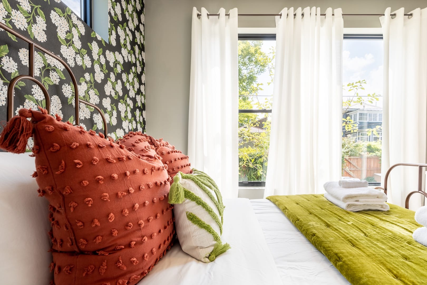 Bright bedroom with colorful pillows.