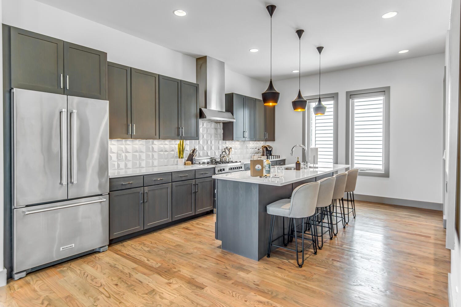 Modern kitchen with island and stools.