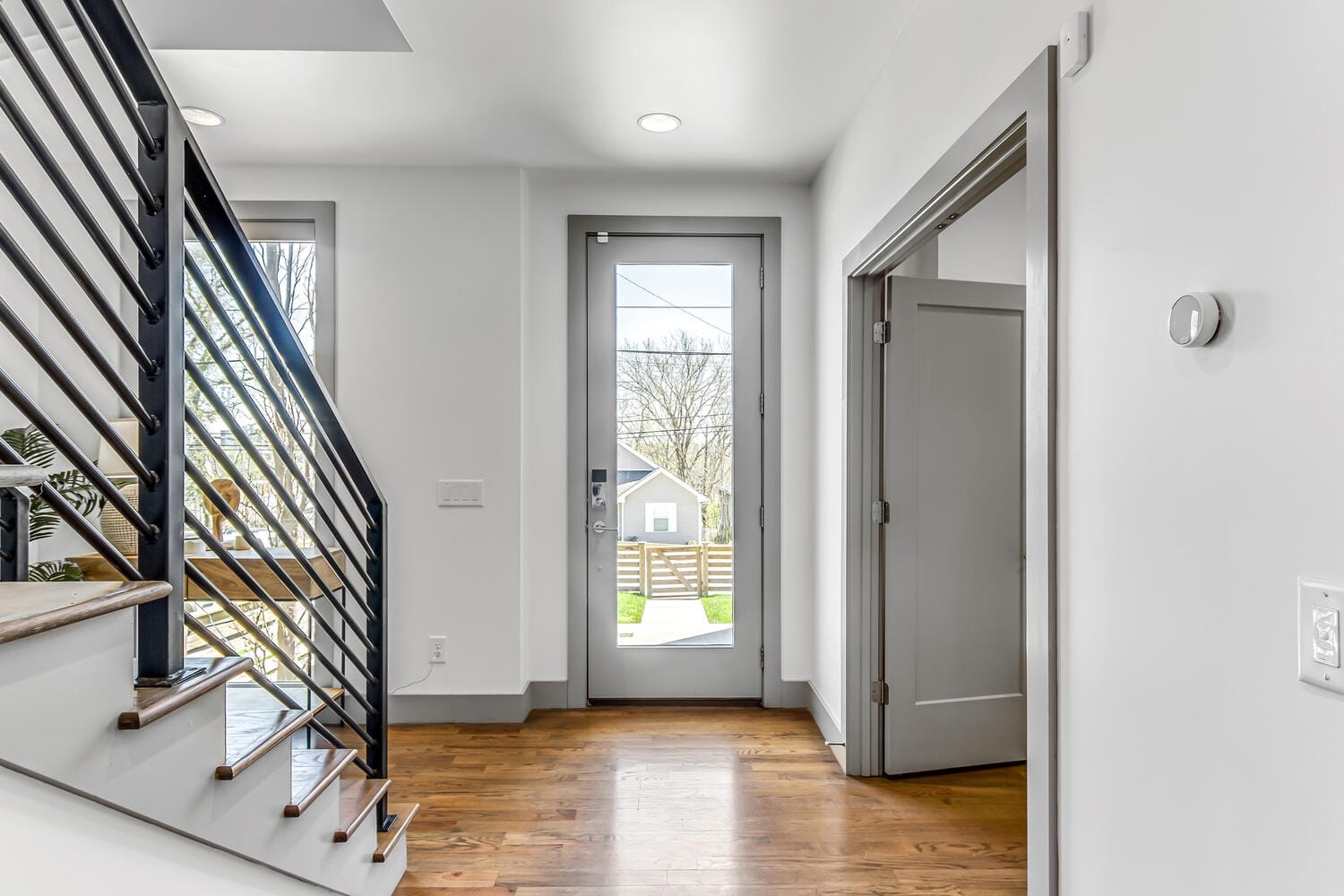 Modern entryway with wooden stairs.