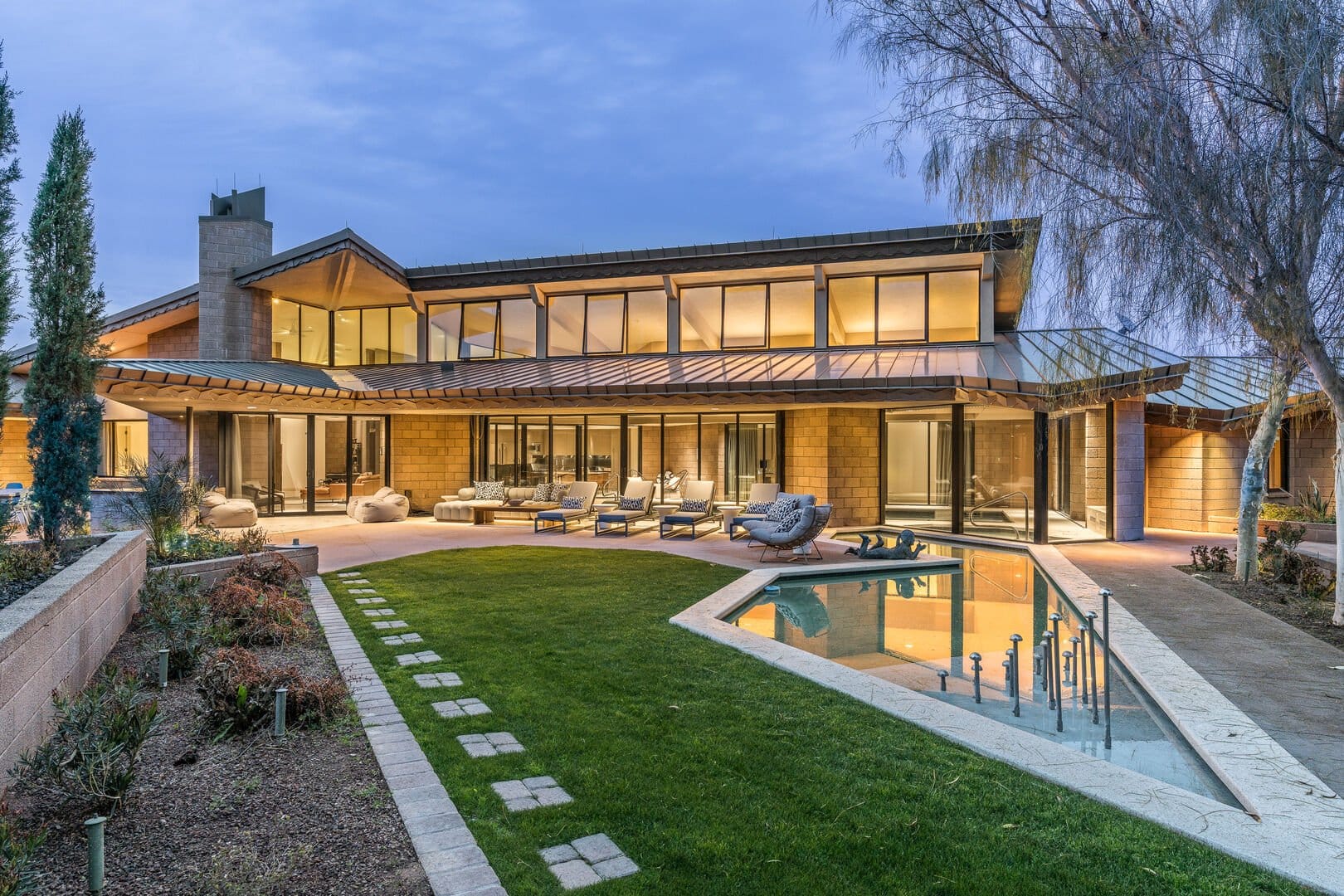 Modern house with pool at dusk.