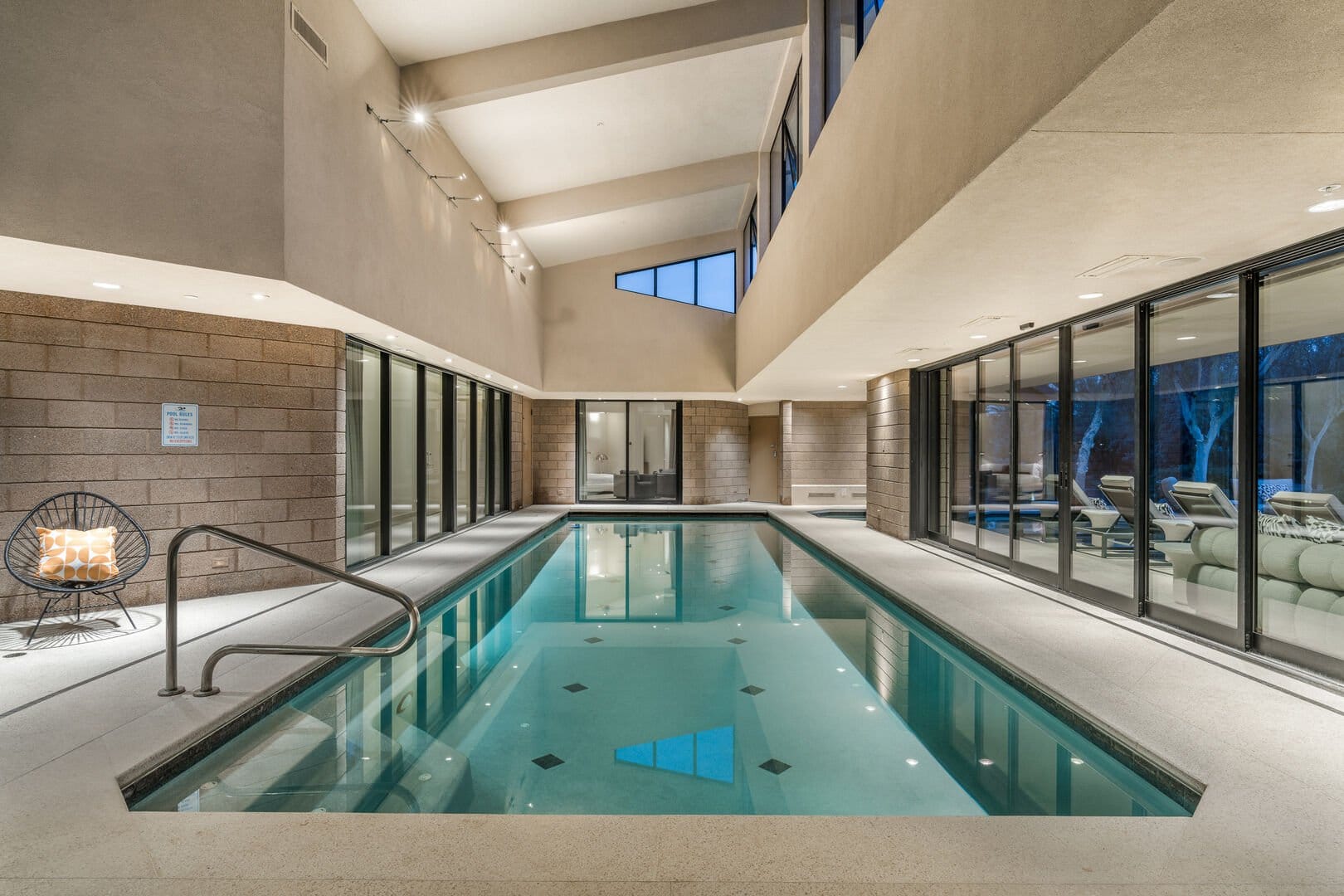 Indoor pool area with lounge chairs.