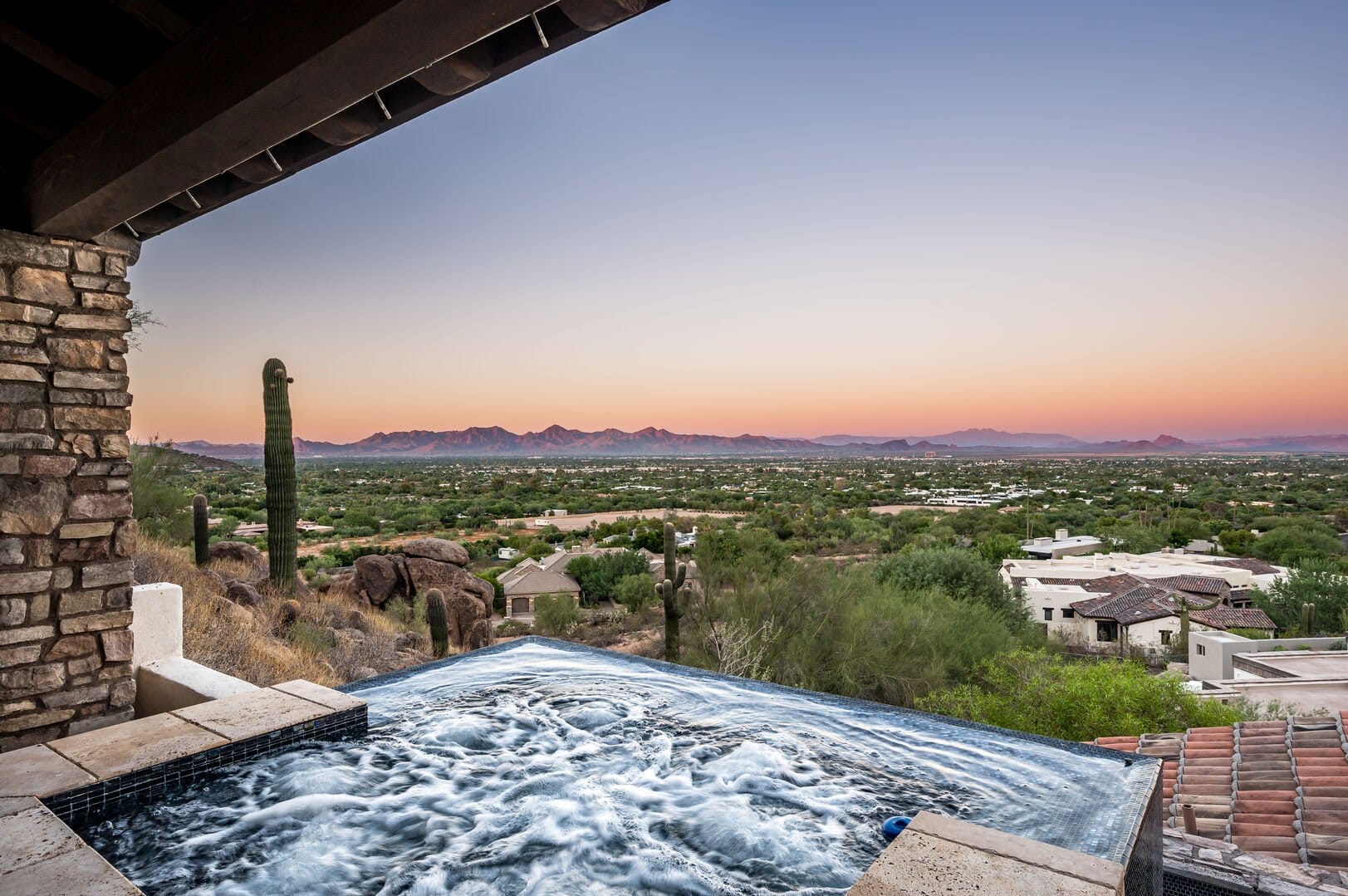 Jacuzzi overlooking desert valley sunset.