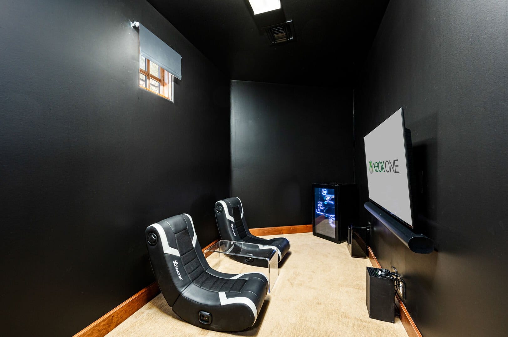 Black-walled gaming room with chairs.