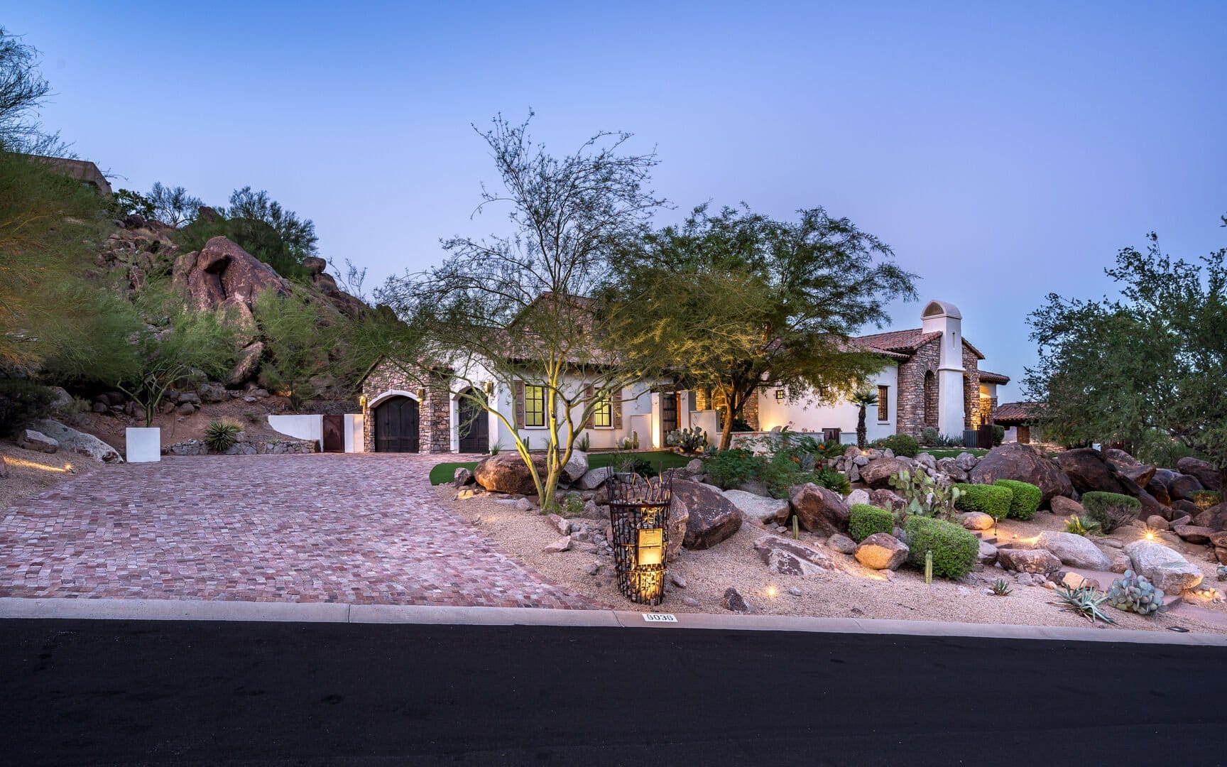 Desert home with brick driveway.