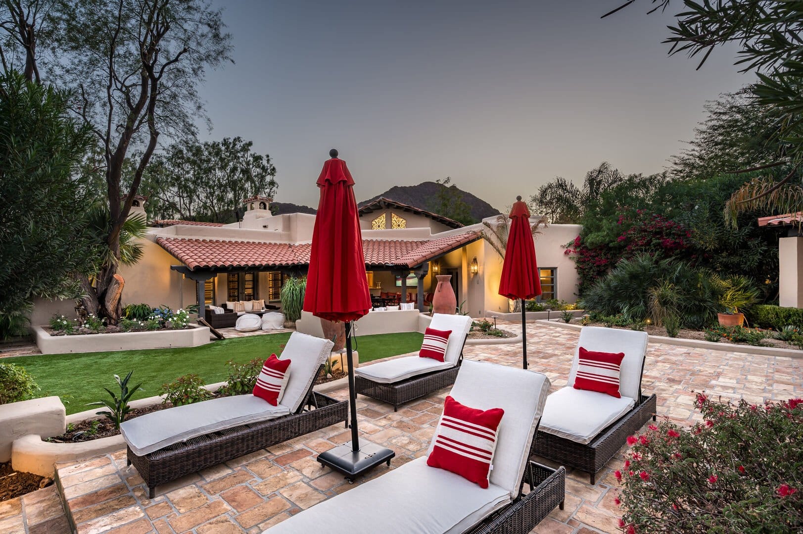 Backyard with patio furniture, umbrellas.