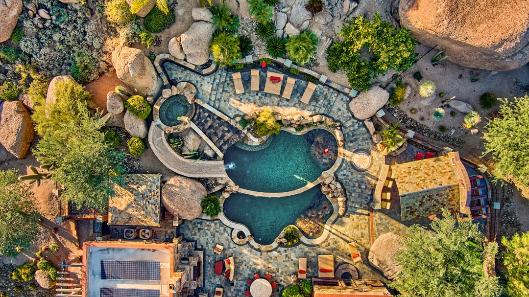 Desert landscape with uniquely shaped pool.