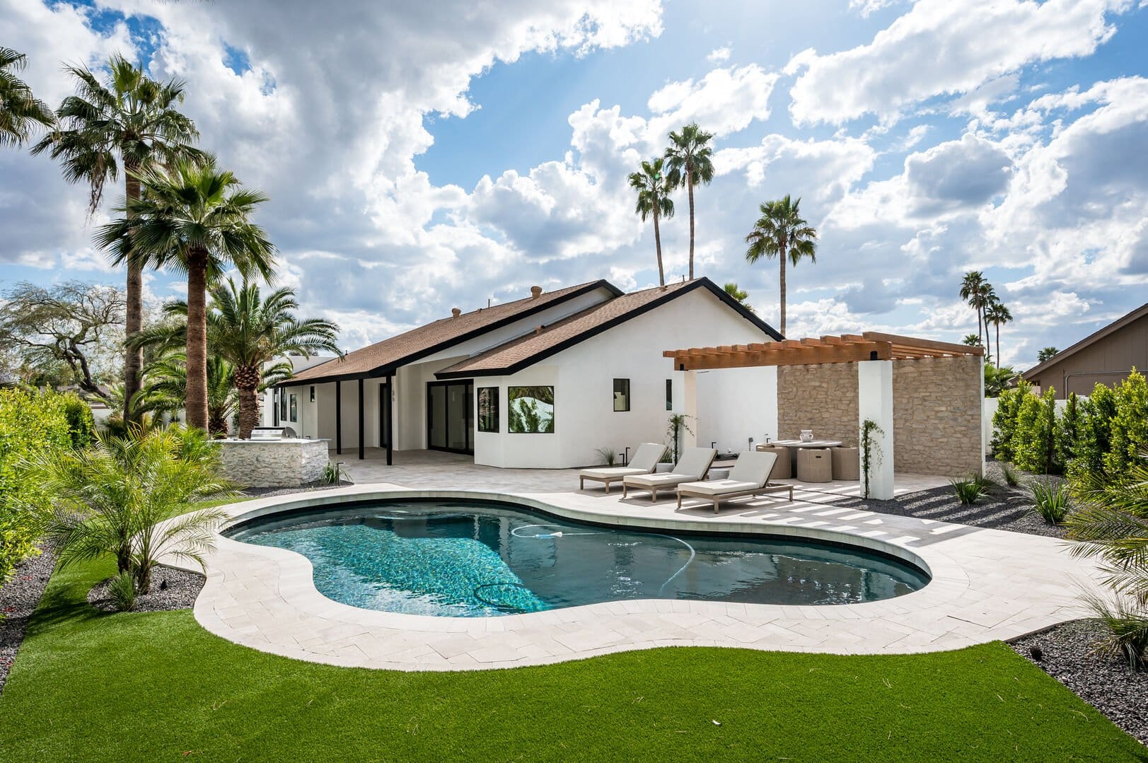 Backyard with pool and lounge area.