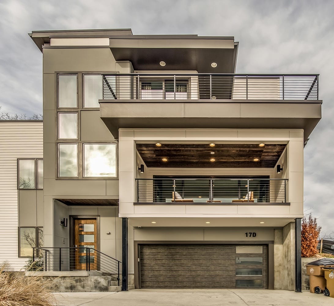 Modern multi-story house with balcony.