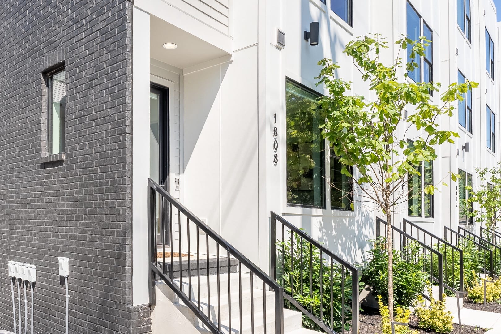 Modern townhouse entrance with steps.