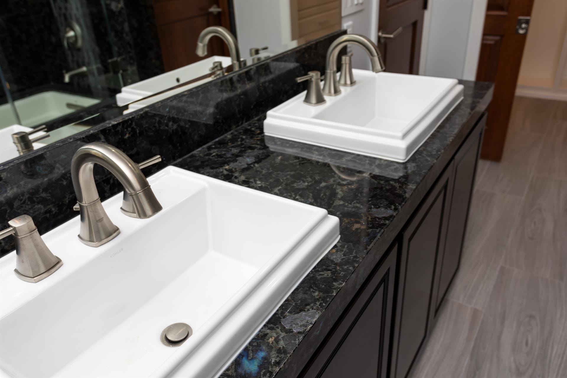 Double bathroom sinks with granite countertop.