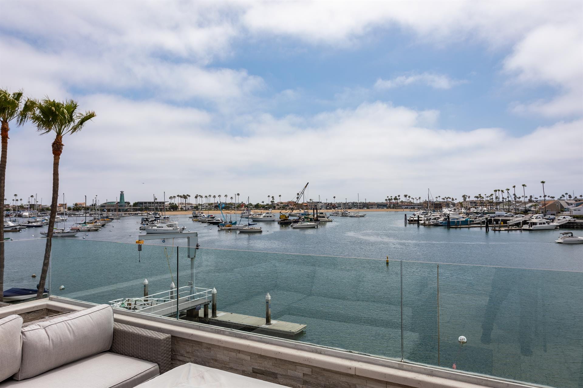 Harbor view with boats, palm trees.