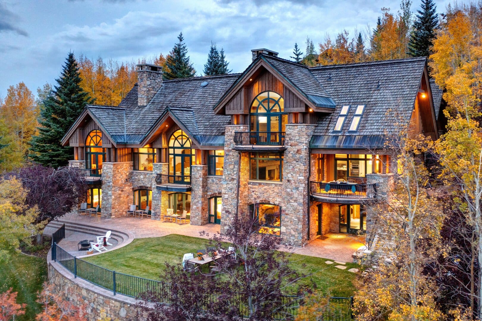 Large rustic mansion surrounded by trees.