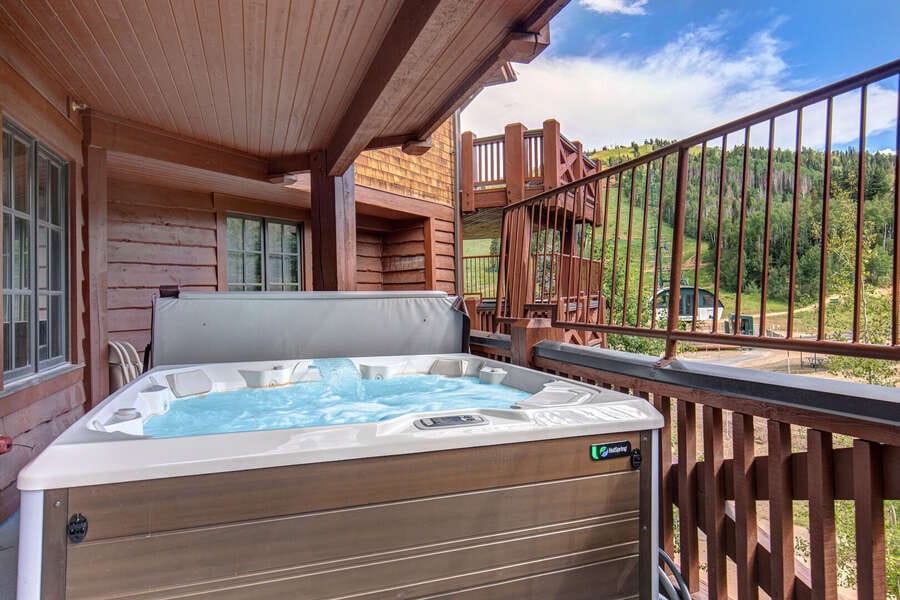 Hot tub on wooden balcony.