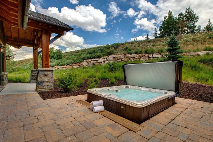 Outdoor hot tub near rustic house.