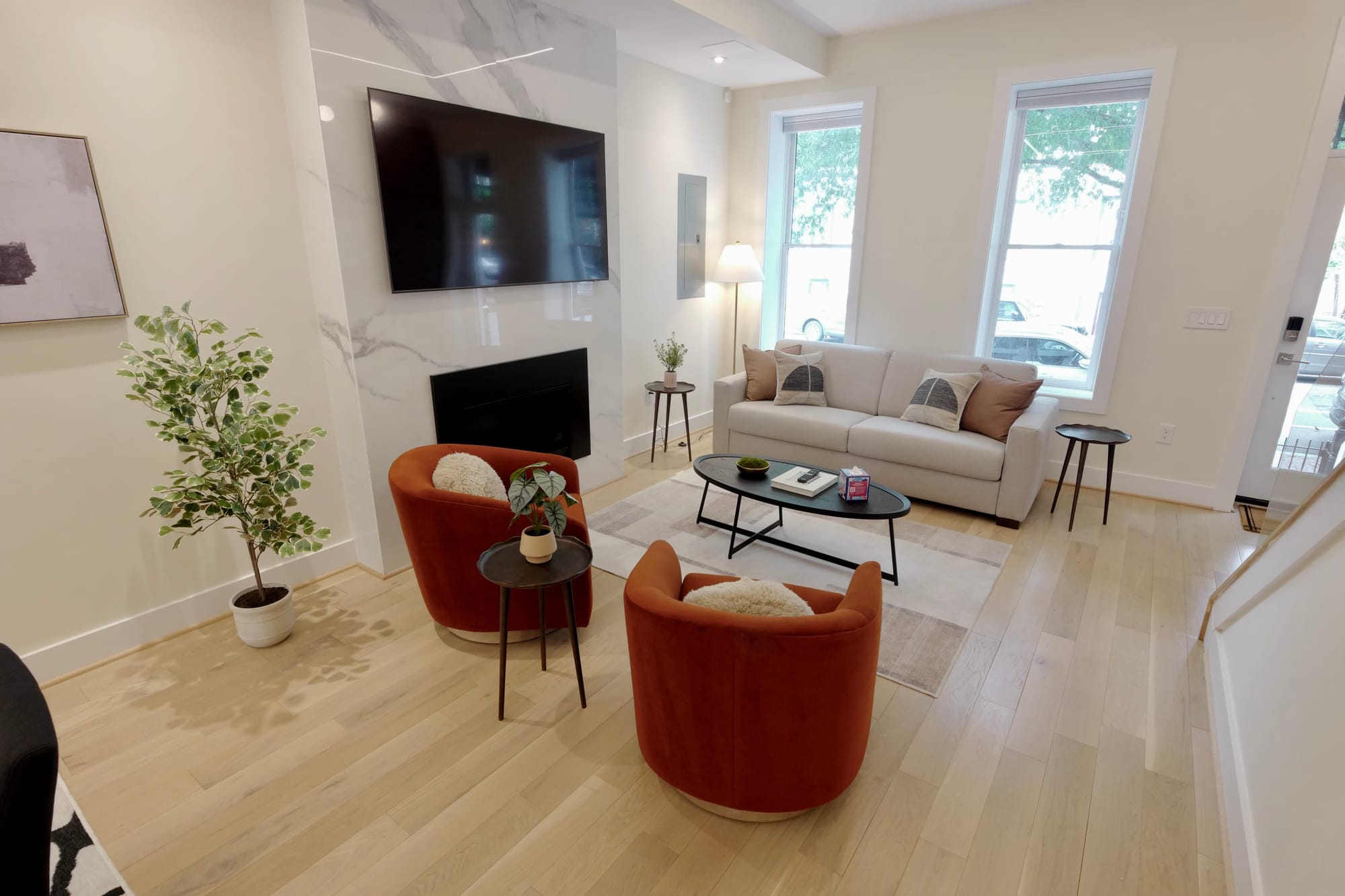 Modern living room with orange chairs.