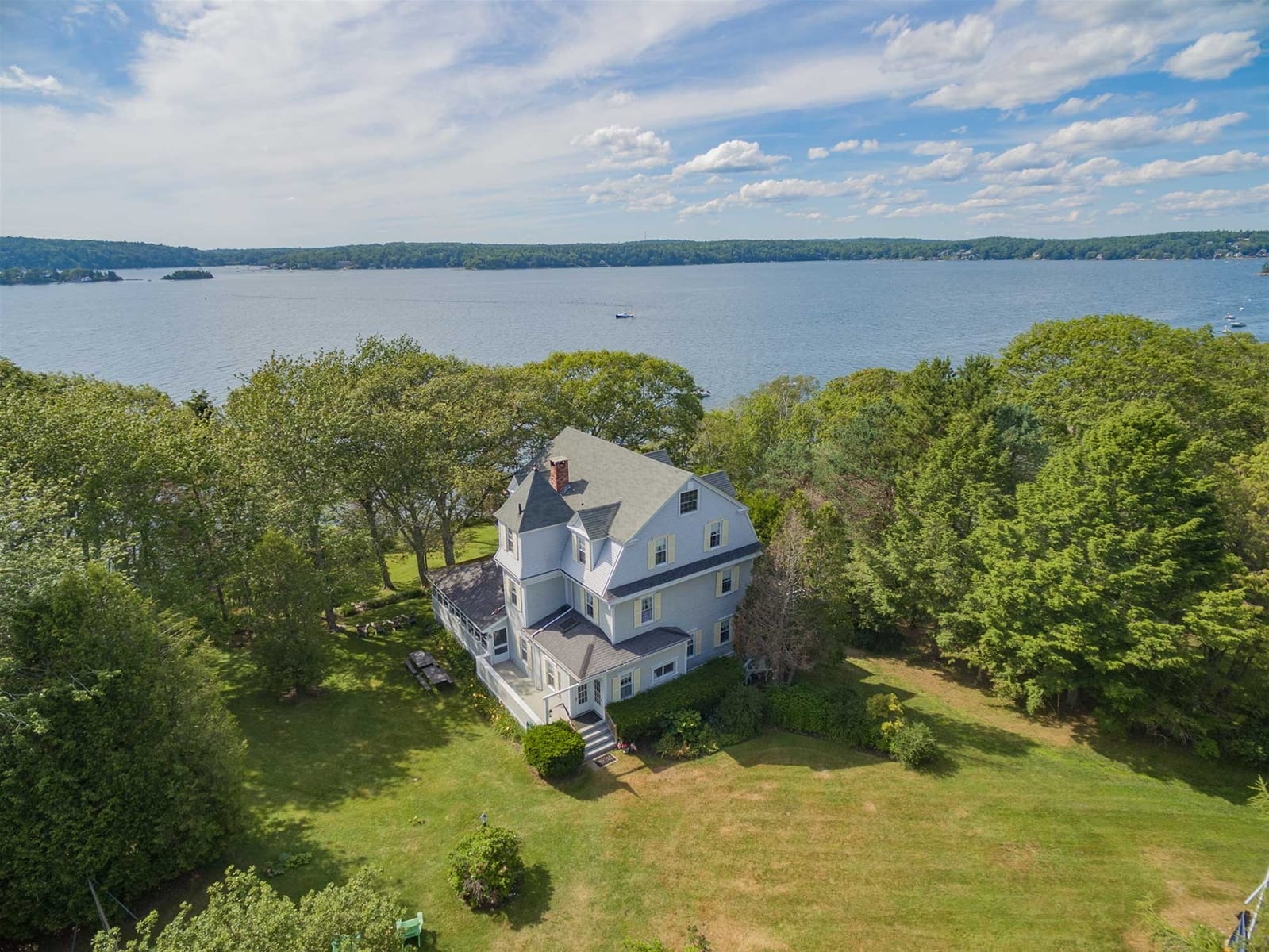 House near trees overlooking a lake.