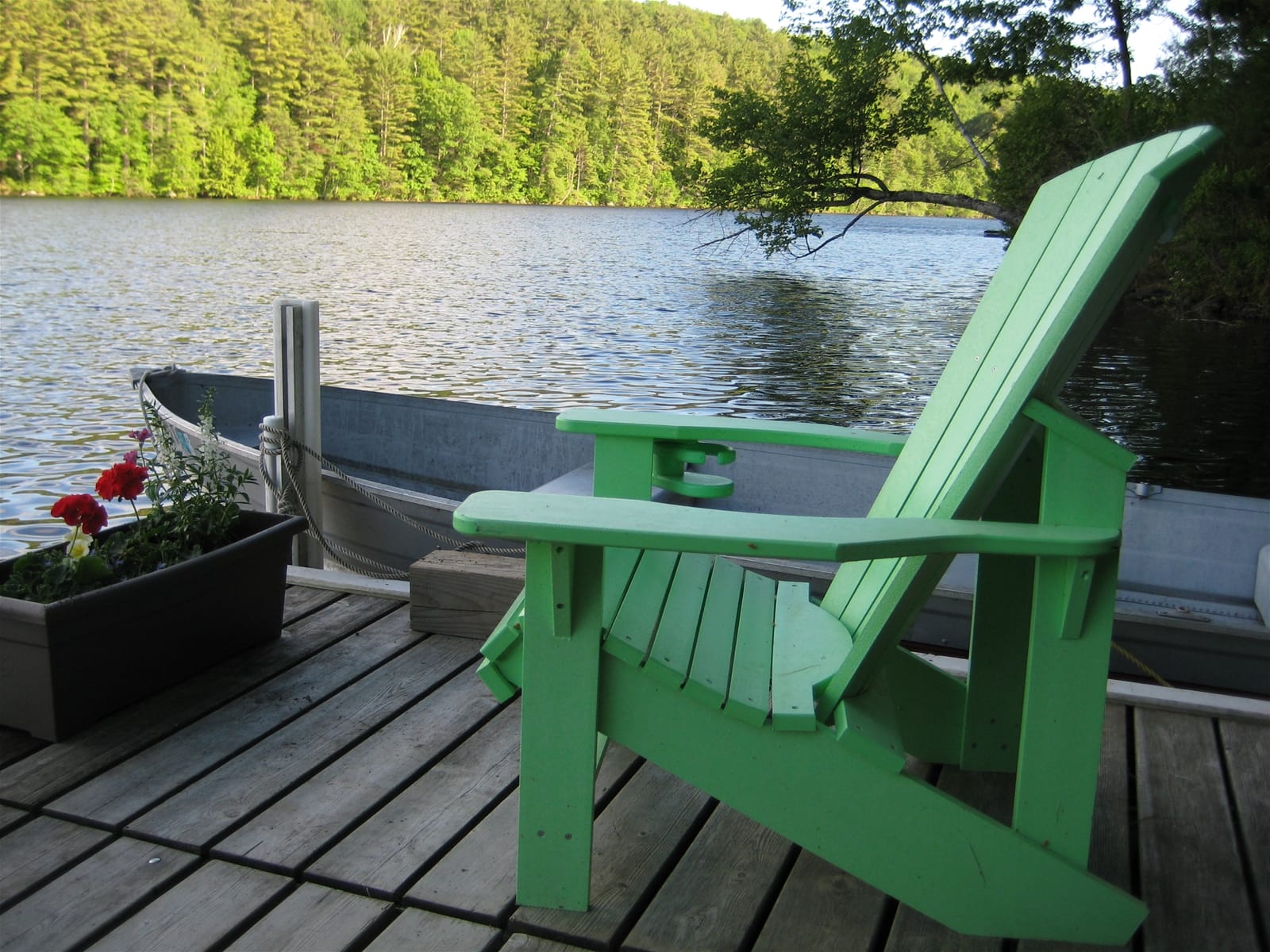 Green chair on lakeside dock.