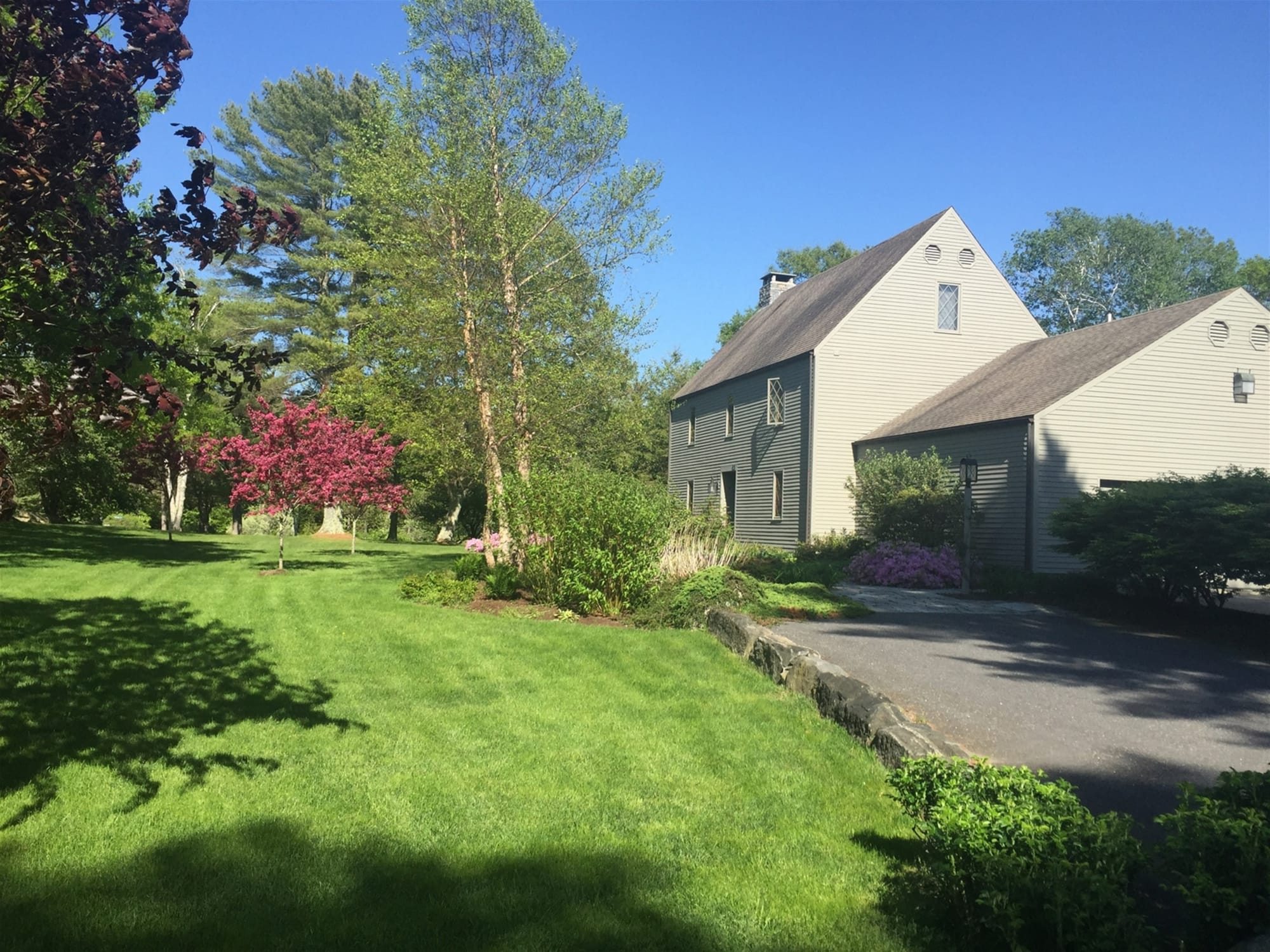 House with green lawn and trees.