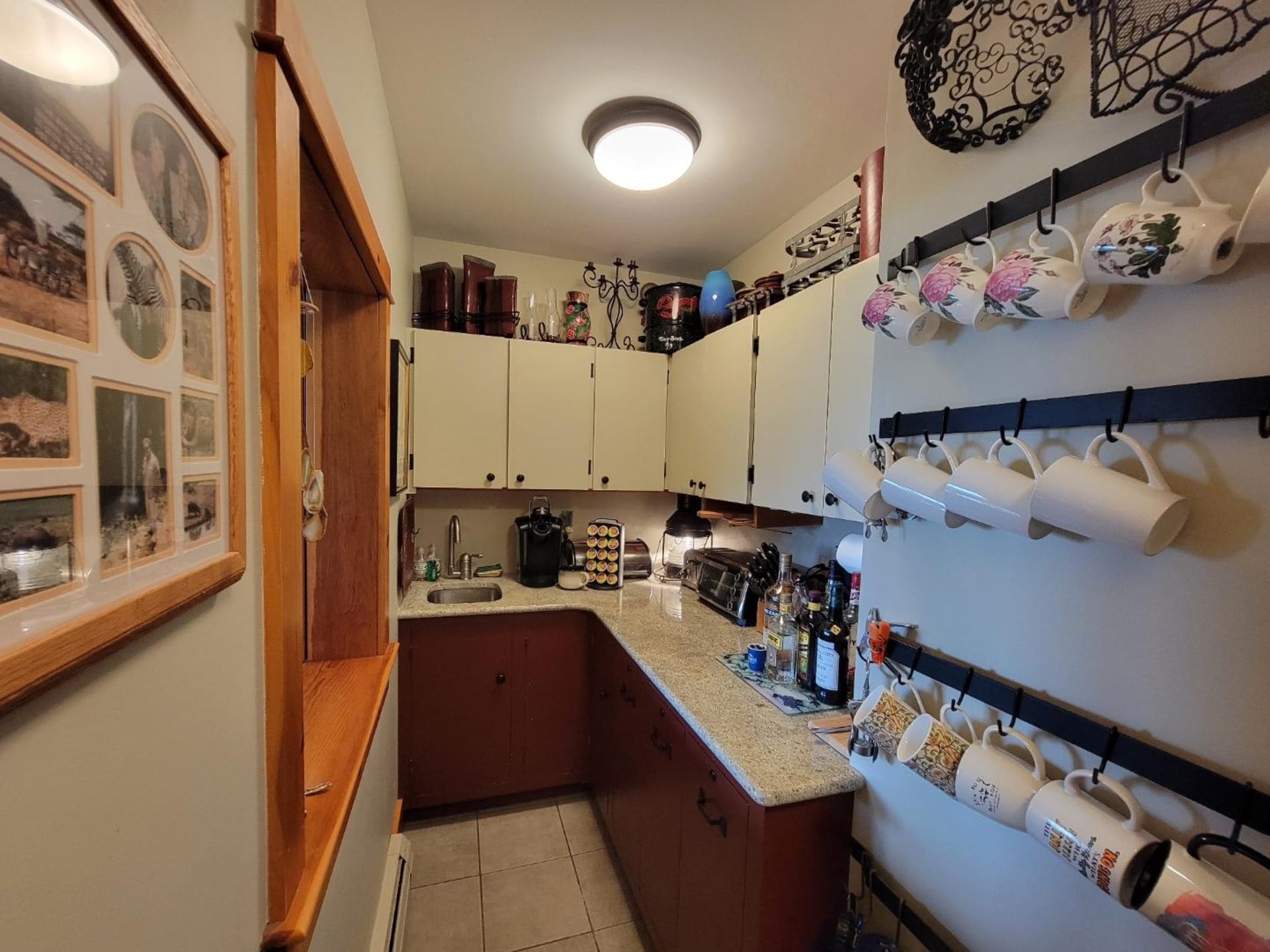 Compact kitchen with hanging mugs.