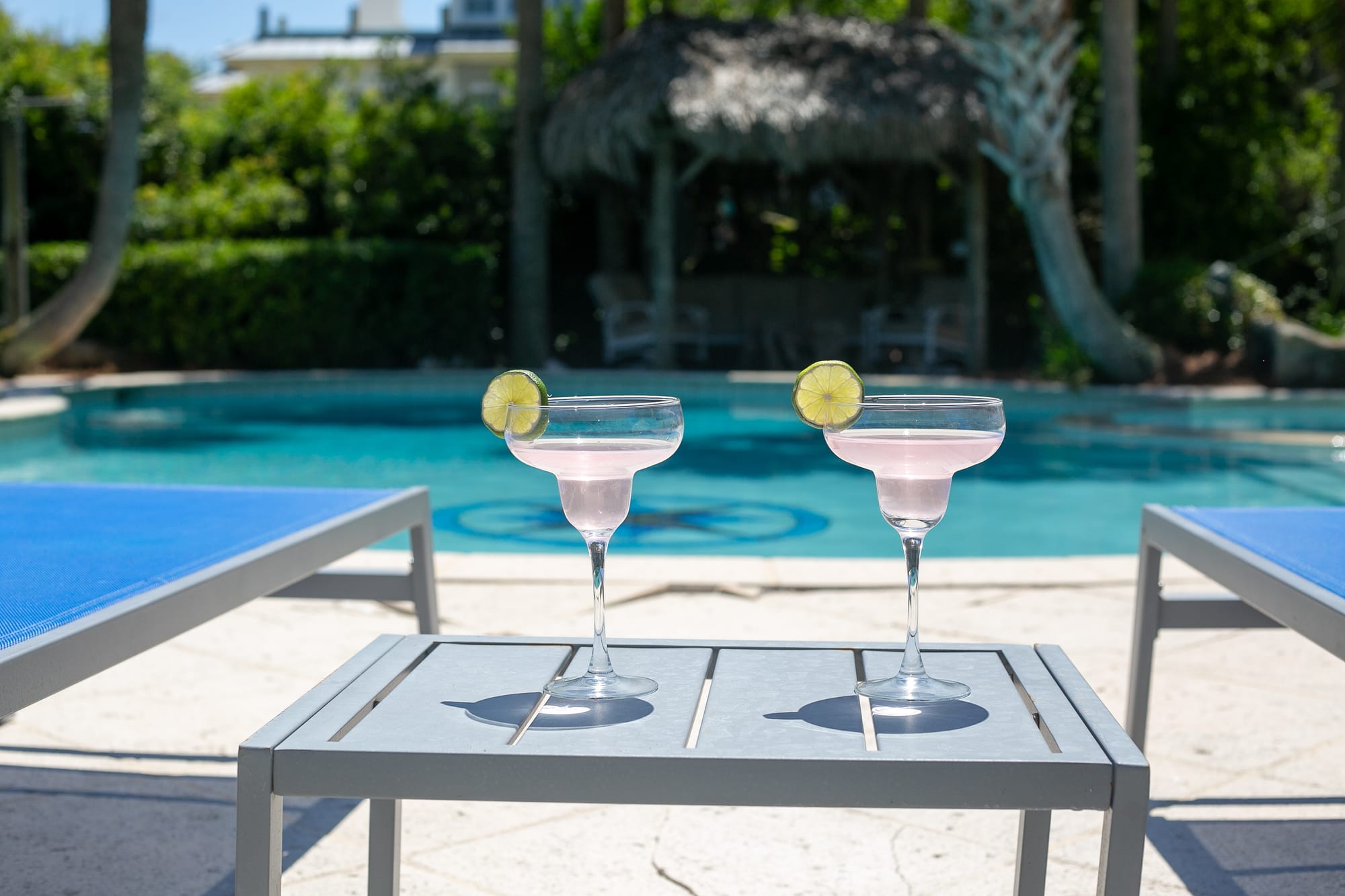 Two cocktails by a pool.