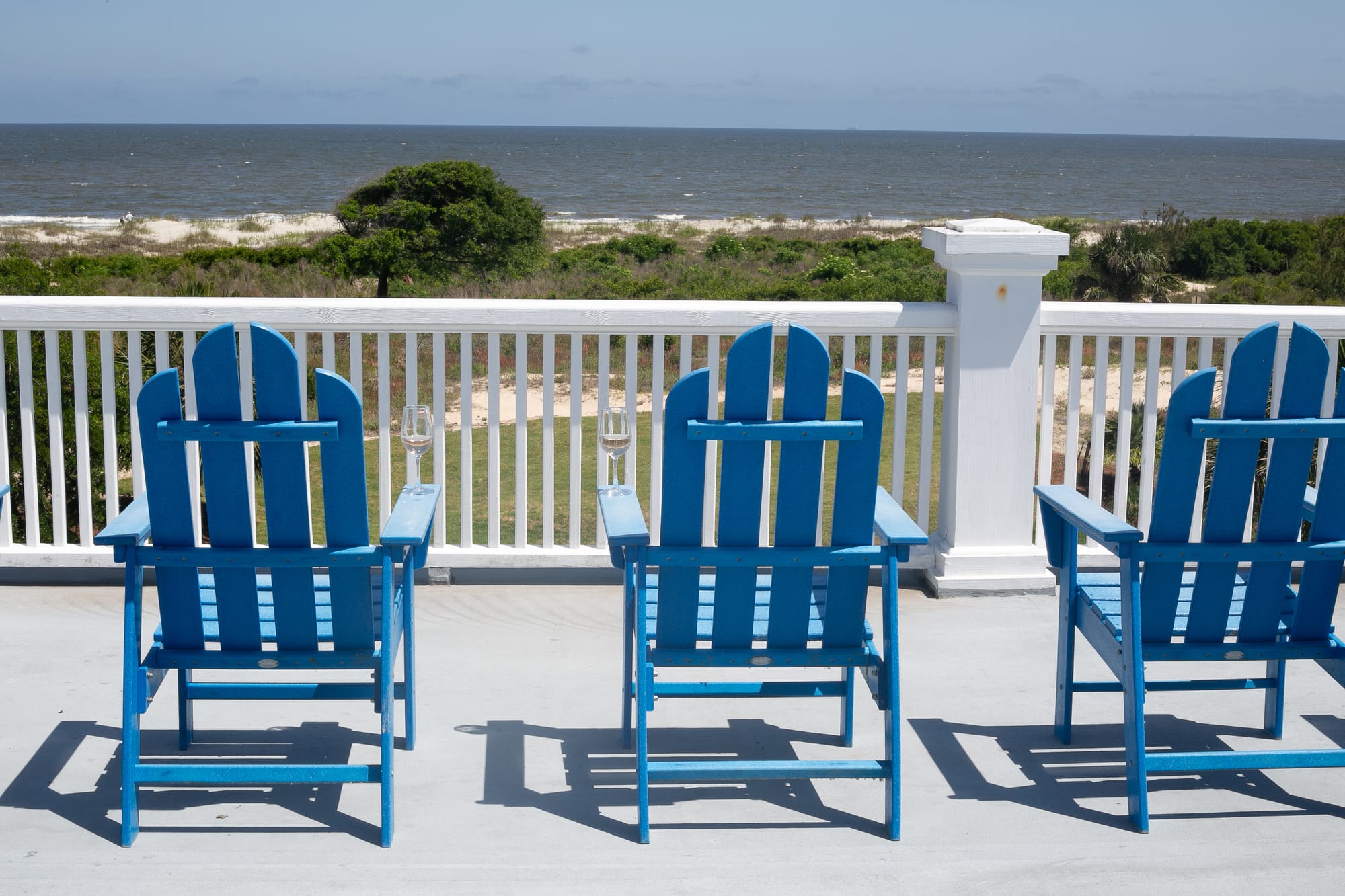 Blue chairs overlooking beach scenery.