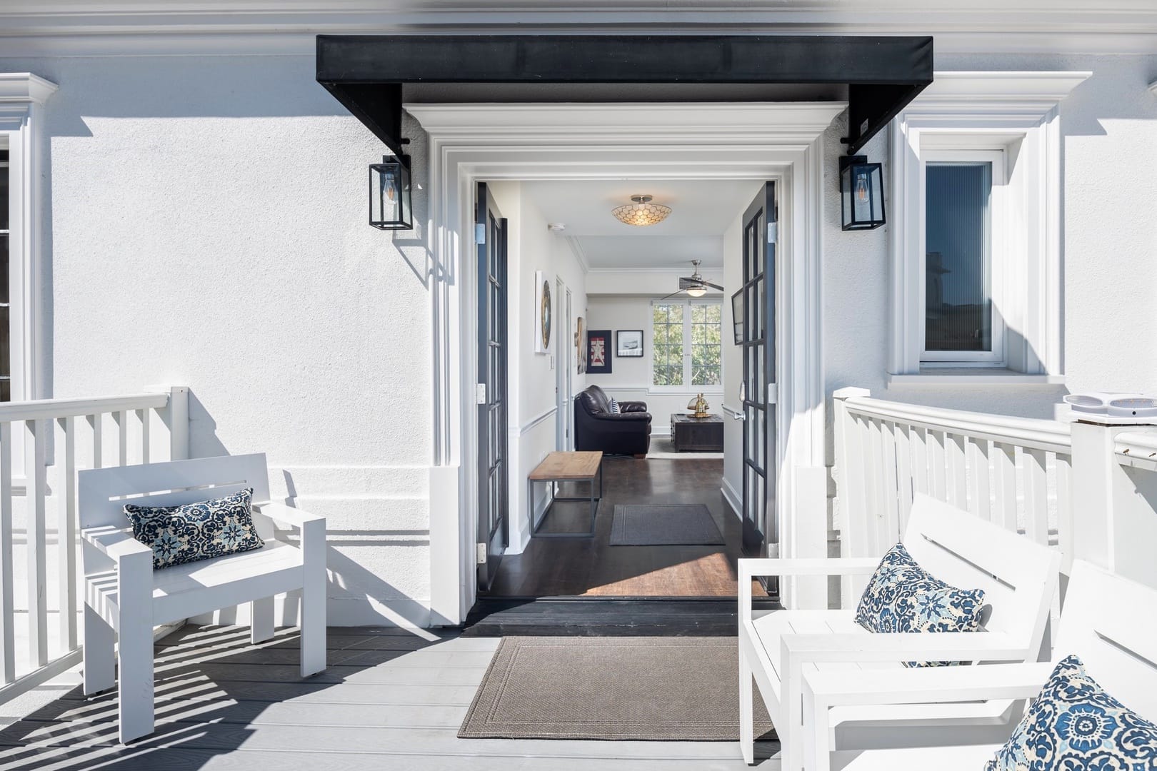 White porch with seating area.