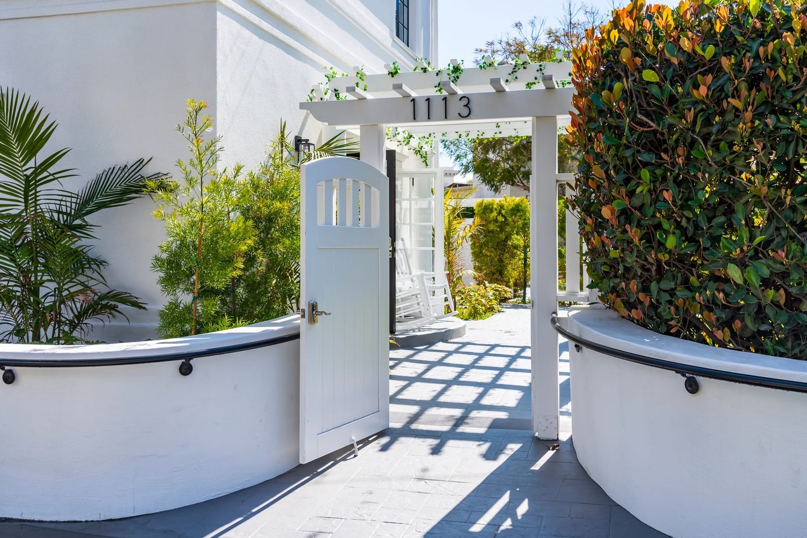 White gate entrance with greenery.