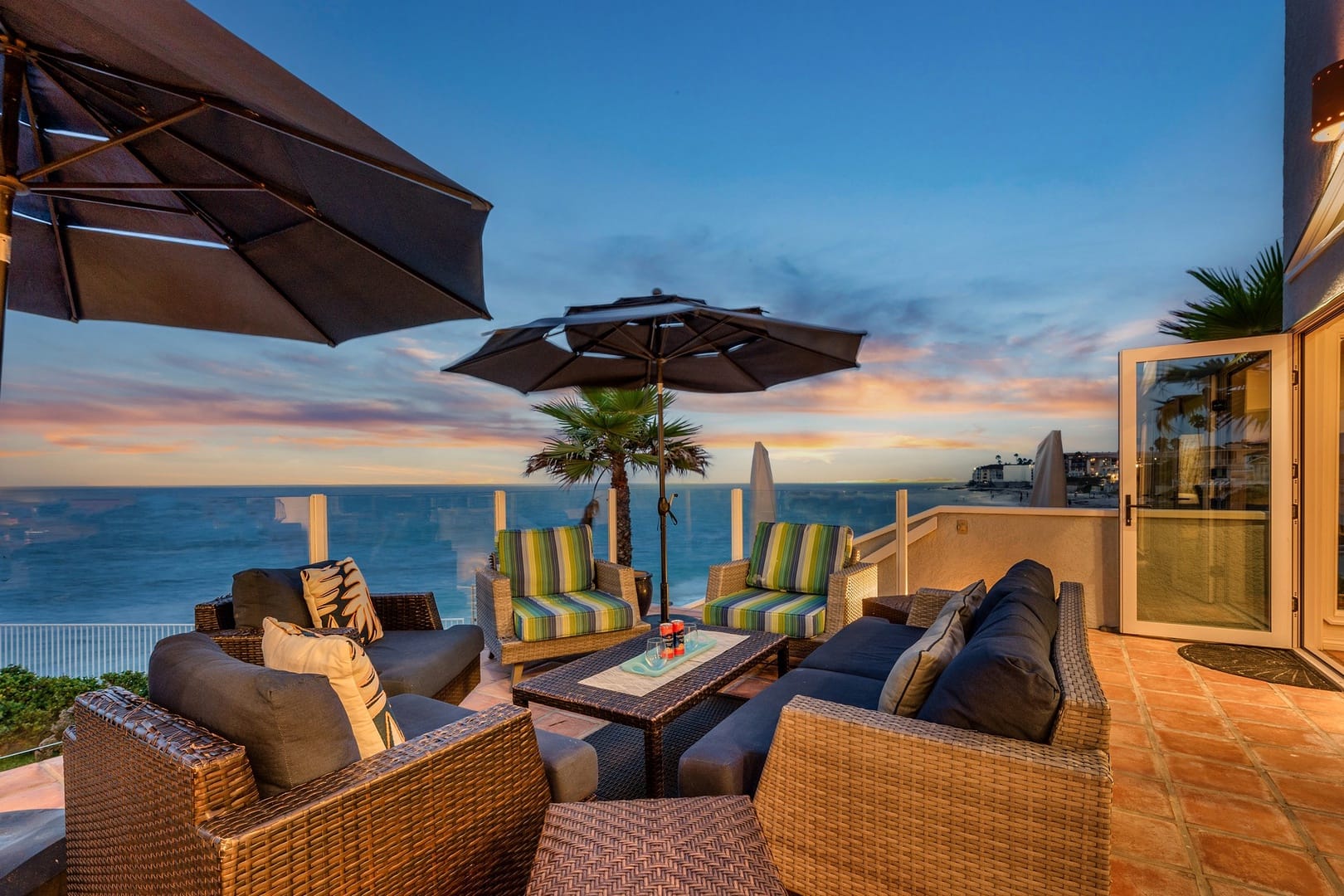 Oceanfront patio with seating at sunset.