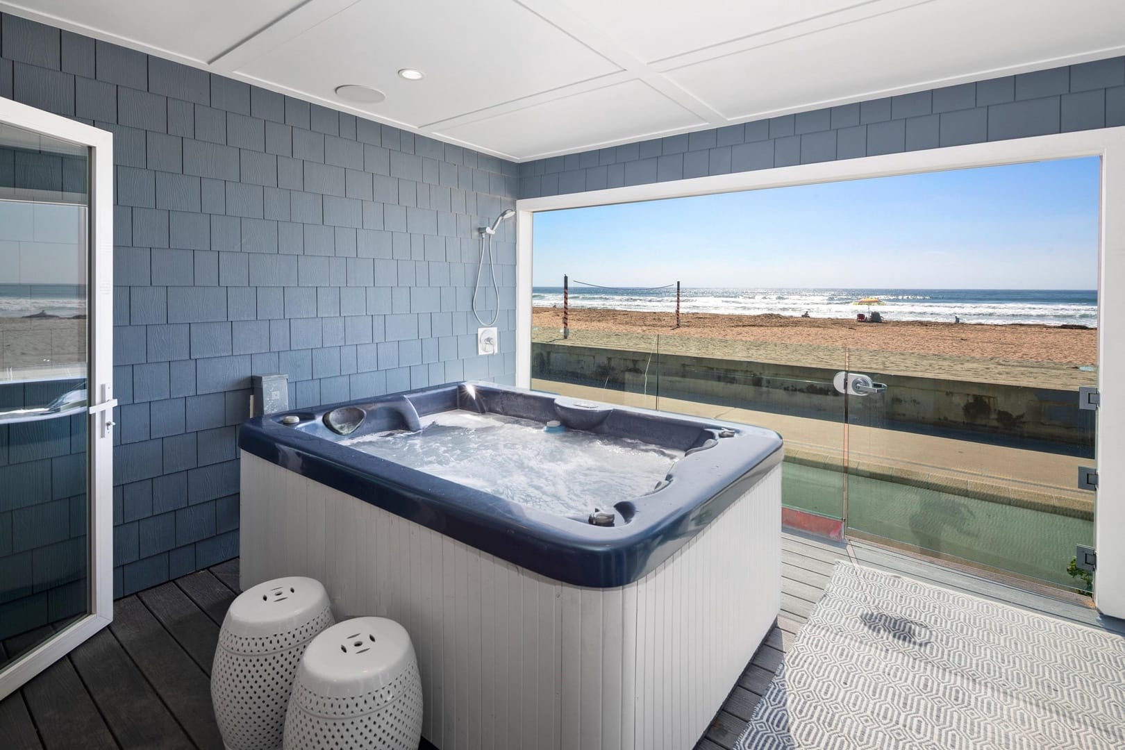 Indoor hot tub with beach view.