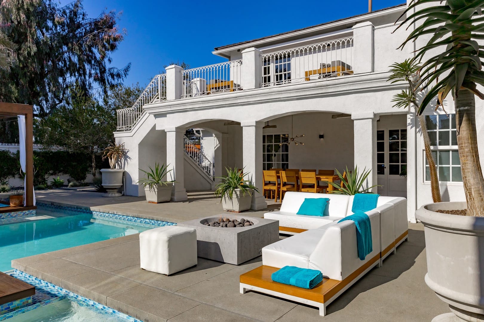 Elegant poolside patio with seating.