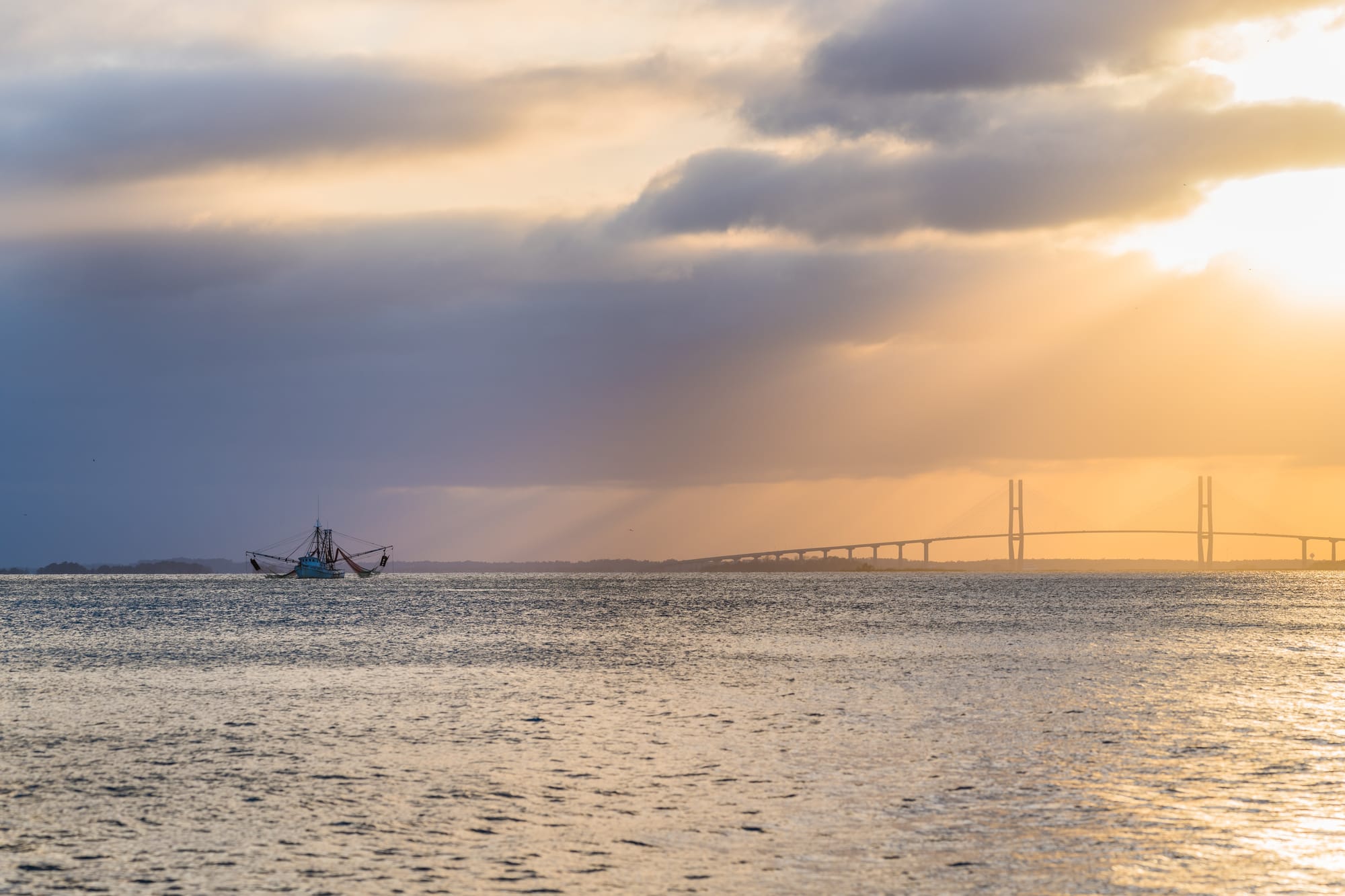 Boat on water with sunrise background.