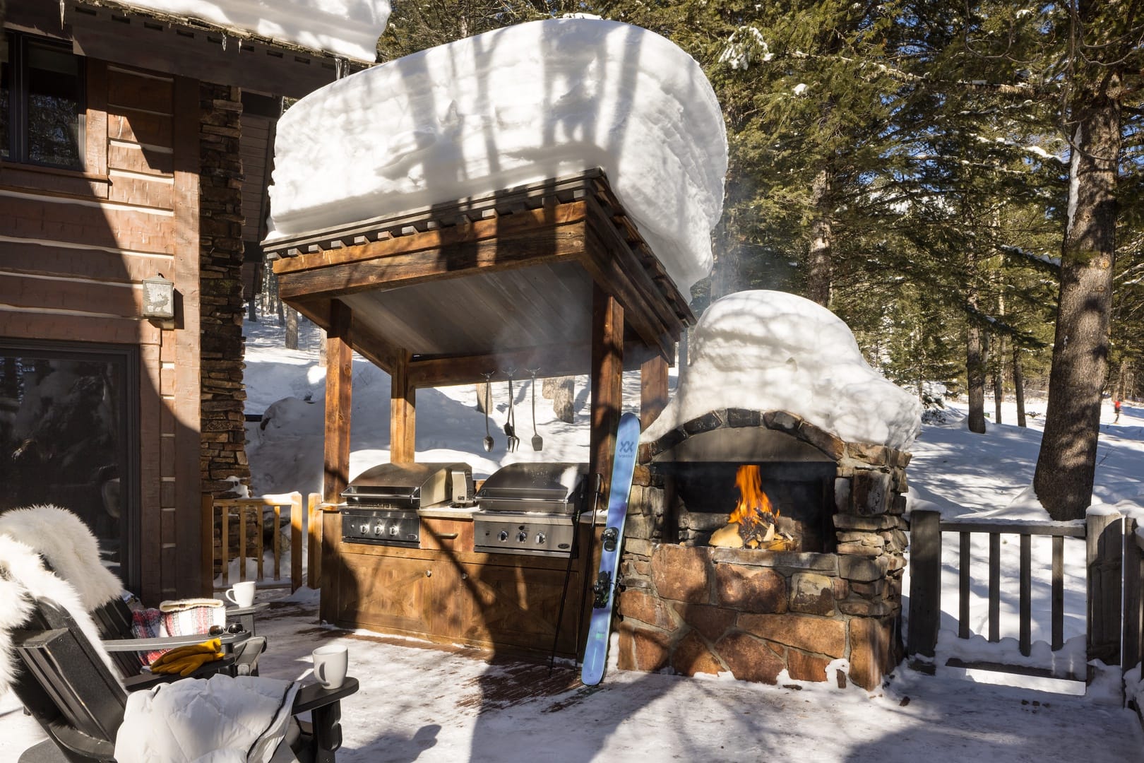 Snow-covered outdoor grill and fireplace.