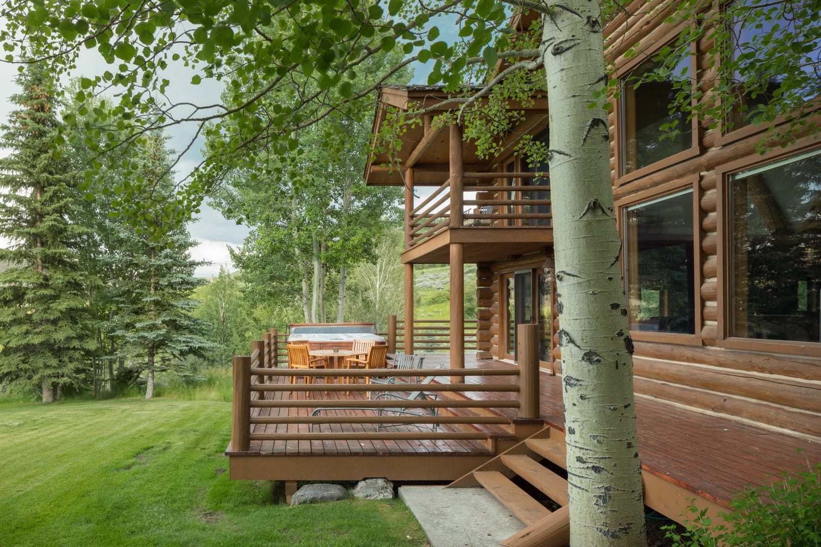 Log cabin with deck in forest.