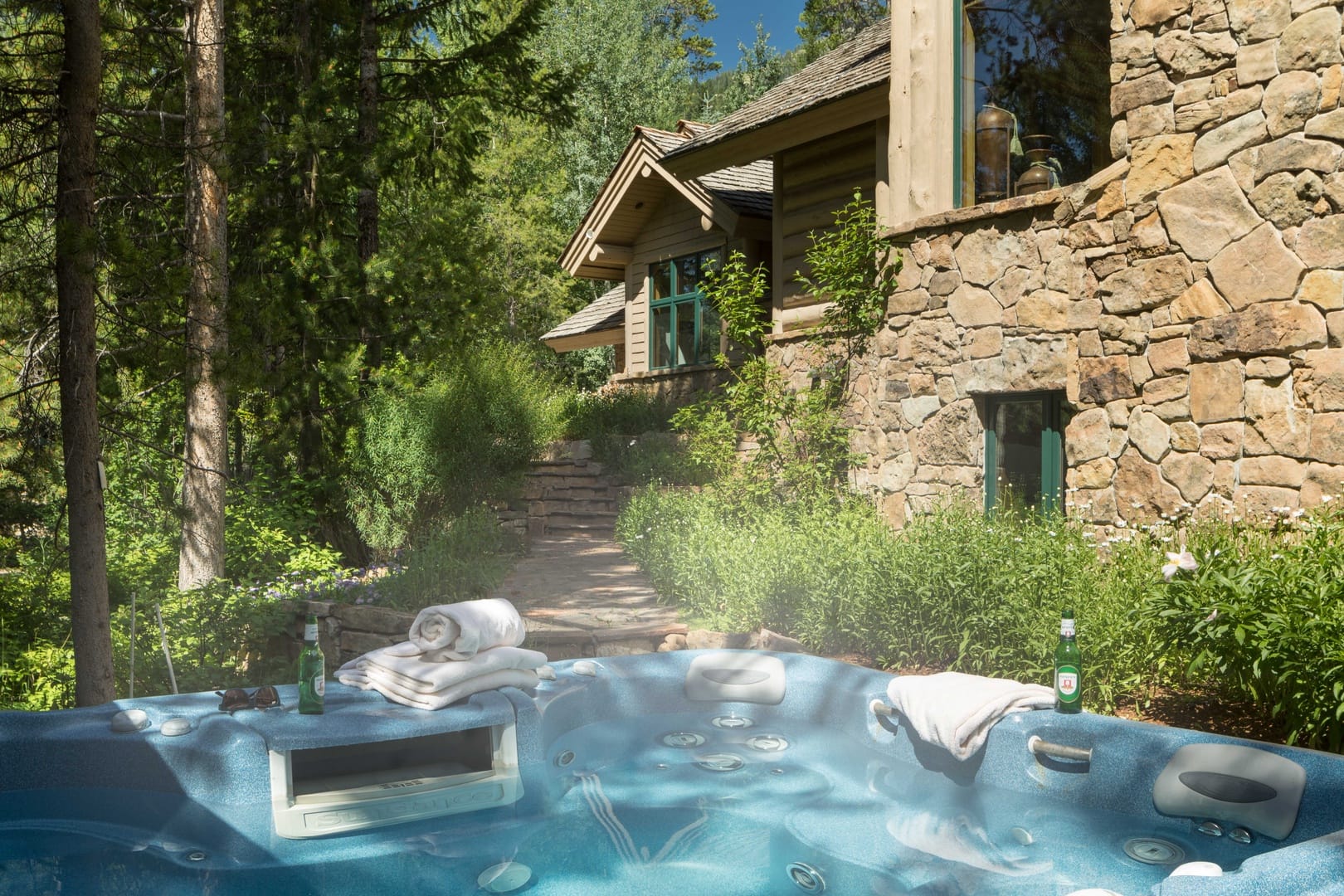 Hot tub outside stone house.