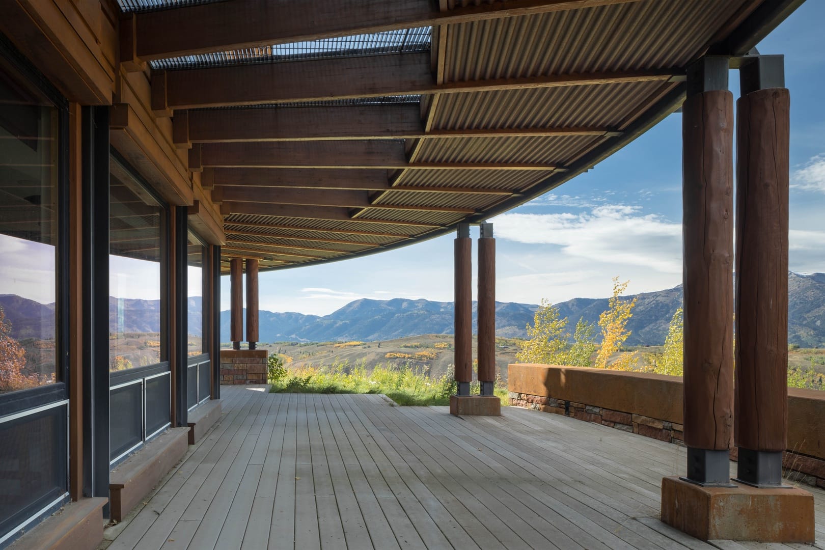 Covered deck overlooking mountainous landscape.