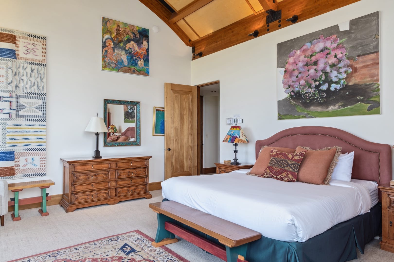 Bedroom with colorful decor and artwork.