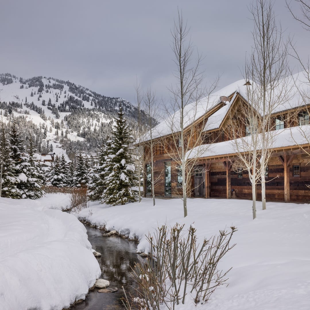 Snow-covered cabin and mountain scenery.