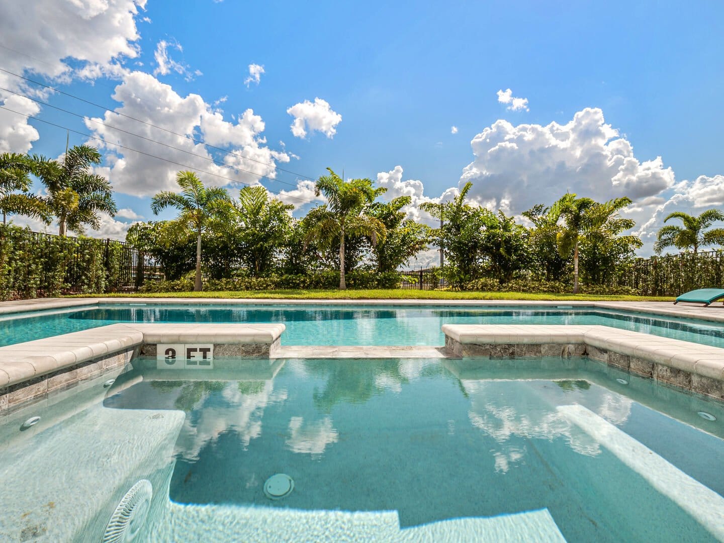 Backyard pool with lush greenery.